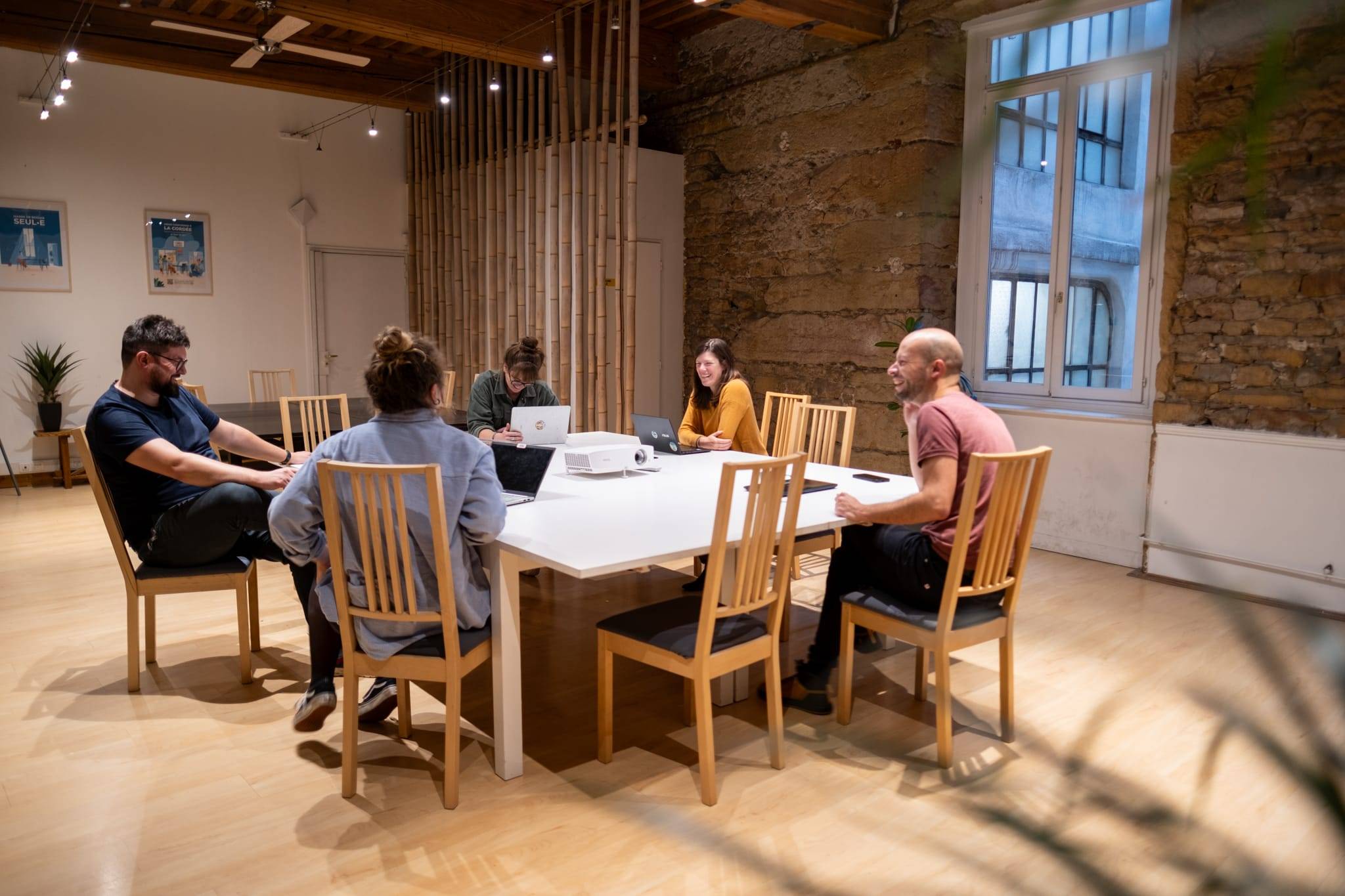 Équipe en réunion autour d'une grande table dans un espace de charme, La Cordée Lyon 1er Terreaux – Opéra Équipe en réunion autour d'une grande table dans un espace de charme, La Cordée Lyon 1er Terreaux – Opéra