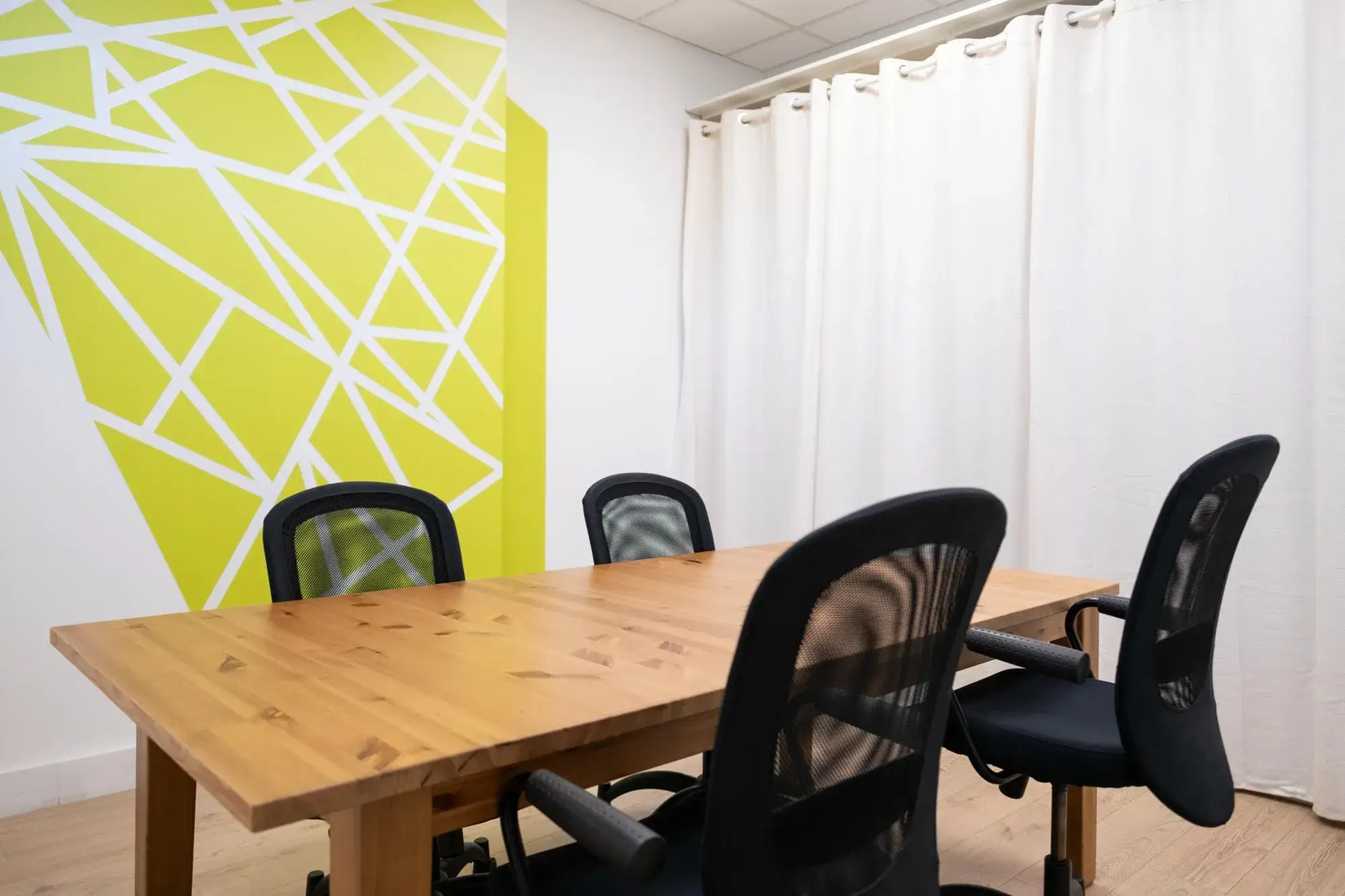 Salle de réunion pour 6 personnes avec mur graphique jaune, La Cordée Villeurbanne