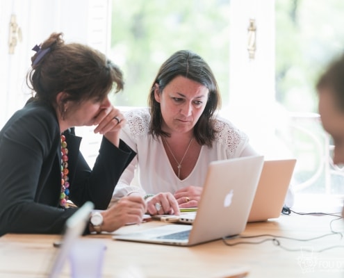 Photo de deux personnes en train de travailler sur leurs ordinateurs